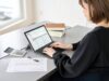 Asian woman entering journal entries in accounting software