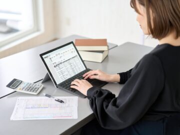 Asian woman entering journal entries in accounting software