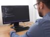 Programmer in Glsses Typing New Lines of HTML Code. Web Design Business and Web Development Concept
