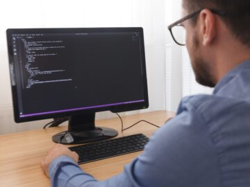 Programmer in Glsses Typing New Lines of HTML Code. Web Design Business and Web Development Concept