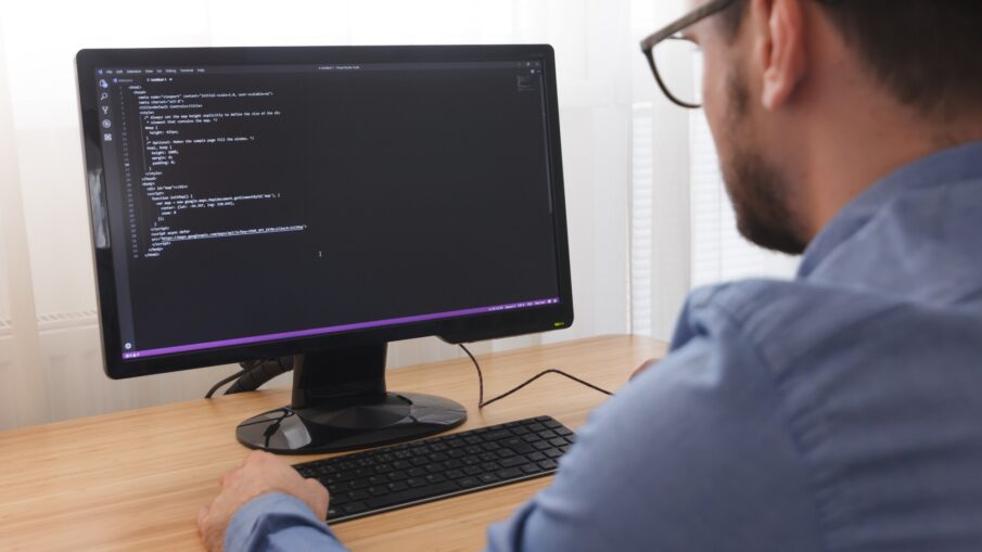 Programmer in Glsses Typing New Lines of HTML Code. Web Design Business and Web Development Concept