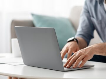 Working at laptop pc. Male hands on pc keyboard, typing text or programming code in computer