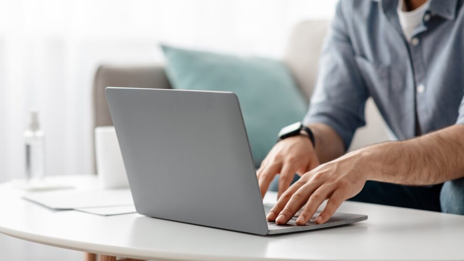 Working at laptop pc. Male hands on pc keyboard, typing text or programming code in computer